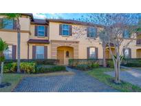 Two-story townhome with landscaping and brick driveway at 227 Verona Ave, Davenport, FL 33897