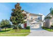 Two-story house with red door, attached garage, and manicured lawn at 2659 Dinville St, Kissimmee, FL 34747