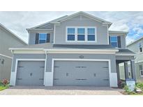 Charming two-story home features a two-car garage and a modern gray facade at 2678 Great Heron Ave, St Cloud, FL 34773