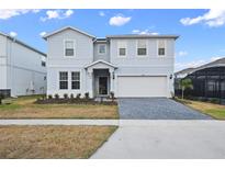 Two-story house with gray siding, paver driveway, and landscaping at 3083 Mahalo Dr, Davenport, FL 33897
