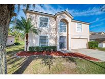 Two-story house with a large yard and attached garage at 8102 Settlers Creek Cir, Lakeland, FL 33810