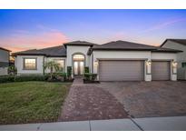 Two-story house with a three-car garage, and a landscaped front yard at 1954 Filly Trl, Oviedo, FL 32765