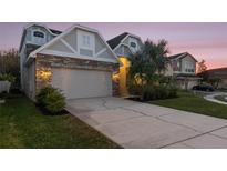 Charming two-story home with a stone facade, two-car garage, and well-manicured lawn at 2555 Sand Arbor Cir, Orlando, FL 32824