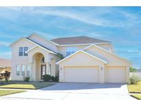 Two-story house with a three-car garage and manicured lawn at 2642 Maggiore Cir, Kissimmee, FL 34746