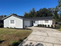 Newly renovated single-story home with a spacious driveway and well-manicured lawn at 407 Parson Brown Way, Longwood, FL 32750