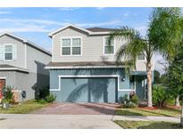 Two-story house with gray siding, blue garage door, and palm trees at 671 Bloom Ter, Davenport, FL 33837