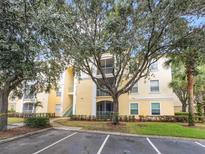 Condo building exterior with lush landscaping and ample parking at 8836 Dunes Ct # 307, Kissimmee, FL 34747