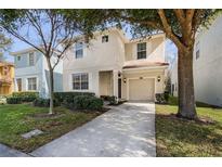 Two-story house with a driveway, landscaping, and attached garage at 8882 Candy Palm Rd, Kissimmee, FL 34747