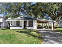 Charming white bungalow with green metal roof, covered carport, and well-maintained lawn at 122 Magnolia Dr, Winter Haven, FL 33881