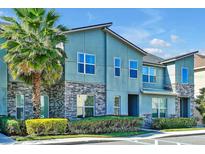 Modern 2-story townhome with stone accents and palm trees at 1552 Carey Palm Cir, Kissimmee, FL 34747