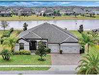 Aerial view of a single-Gathering home with a lake view and a large backyard at 17608 Sailfin Dr, Orlando, FL 32820