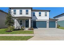 Two-story house with gray siding, white trim, and a two-car garage at 2338 Gold Dust Dr, Minneola, FL 34715