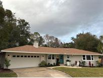 Charming single-story home featuring a brick facade, manicured lawn, and cozy front patio seating at 332 Lake Winnemissett Dr, Deland, FL 32724