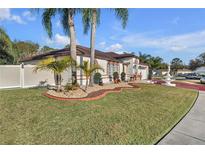 Landscaped front yard with palm trees and a fountain at 539 Pinehurst Cv, Kissimmee, FL 34758