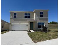 Two-story home featuring a two car garage, neutral color scheme, and a well-manicured front lawn at 5800 Galloping Dr, Apopka, FL 32712