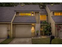 Tan two-story townhome with a white garage door and landscaping at 8133 Citrus Chase Dr, Orlando, FL 32836