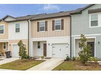 Three-unit townhome building showcasing modern design and attached garages at 161 Mandovi St, Davenport, FL 33837