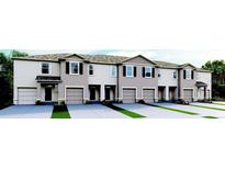 Modern townhouses with attached garages and neatly landscaped lawns at 2203 Tongass Bnd, Davenport, FL 33896