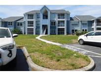 Light blue condo building with balconies, walkway, and parking in front at 2592 Grassy Point Dr # 106, Lake Mary, FL 32746