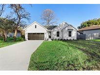 Charming farmhouse-style home with a dark brown garage door and manicured lawn at 58 Bonita Rd, Debary, FL 32713