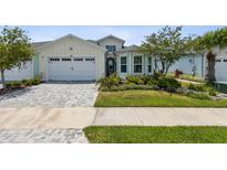 House exterior featuring a two-car garage and well-manicured lawn at 597 Lost Shaker Way, Daytona Beach, FL 32124