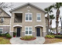 Two-story condo building with two units, featuring balconies and landscaping at 6554 Swissco Dr # 53, Orlando, FL 32822