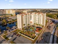 Aerial view of a modern apartment building with pool and parking at 7383 Universal Blvd # 207, Orlando, FL 32819