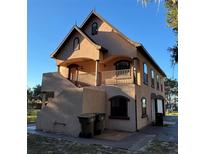 Two-story house with stucco exterior, balcony, and attached garage at 9002 Lakeshore Dr, Yalaha, FL 34797