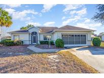 Single-story house with a screened garage and landscaped yard at 17478 Se 115Th Terrace Rd, Summerfield, FL 34491