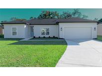 Newly constructed home with a two-car garage and well-manicured lawn at 227 W 4Th St, Chuluota, FL 32766