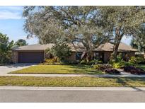 Brick ranch home with mature landscaping and a large tree in the front yard at 230 W Spring Lake Dr, Altamonte Springs, FL 32714