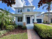 Charming two-story home with a manicured lawn, a covered front porch, and a two-car garage at 7343 Derexa Dr, Windermere, FL 34786