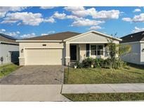 House exterior featuring a two-car garage and well-manicured lawn at 3087 Camden Way, Davenport, FL 33837