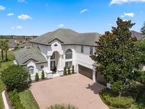 Beautiful two story home with a brick driveway, a tile roof, and mature landscaping at 408 Chelsea Ave, Davenport, FL 33837
