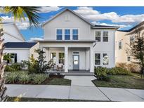 Two-story white house with a front porch and landscaped yard at 210 Hammock Preserve Loop, Winter Garden, FL 34787