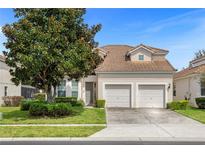 Two-story house with beige exterior, double garage, and landscaping at 2549 Archfeld Blvd, Kissimmee, FL 34747