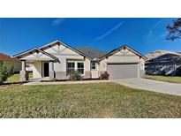 One-story home with a two-car garage and landscaped lawn at 3342 Saint Vincent Ln, Clermont, FL 34711