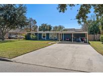 Ranch style home with carport, mature landscaping, and a large yard at 402 Oak Lynn Dr, Orlando, FL 32809