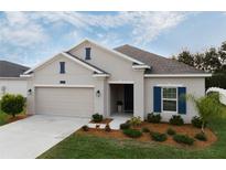 One-story home with beige exterior, blue shutters, and landscaped yard at 4530 Tahoe Cir, Clermont, FL 34714