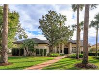 One-story house with a tile roof and palm trees at 4832 Shoreline Cir, Sanford, FL 32771