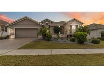 Charming single-story home with a stone facade, well-maintained landscaping, and a two-car garage at 1040 Sadie Ridge Rd, Clermont, FL 34715