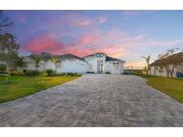 Stunning waterfront home with a paver driveway and beautifully landscaped lawn at 118 River Ln, Ormond Beach, FL 32176