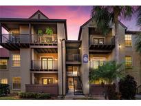 Two-story condo building with balconies and a staircase at dusk at 236 Afton Sq # 103, Altamonte Springs, FL 32714