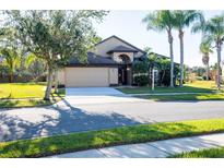 Tan one-story house with a brown door and two-car garage at 2612 Keswick Ct, Kissimmee, FL 34744