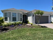 Charming home with a beautifully landscaped front yard featuring vibrant flowers and a well-maintained lawn at 2812 Ruby Rose Ln, St Cloud, FL 34771