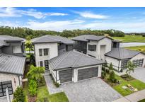 Luxury homes with grey roofs and two-car garages, situated in a golf course community at 3015 Kensington Ave, Davenport, FL 33837