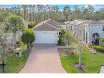 Attractive single-story home with a two-car garage and a brick paver driveway at 560 Presido Park Pl, Kissimmee, FL 34759