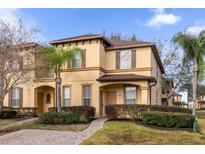 Two-story townhome with brown roof, landscaped yard, and paved driveway at 100 Napoli Dr, Davenport, FL 33897