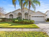 House exterior with a two-car garage and nicely landscaped yard at 11016 Orangeshire Ct, Ocoee, FL 34761