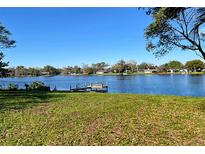 Lush backyard featuring a private dock with bench overlooking a serene lake, perfect for relaxation and enjoying waterfront views at 116 Sheridan Ave, Longwood, FL 32750